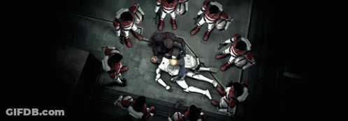Group Standing Around Man Laying On Floor With Sign Saying The GIF