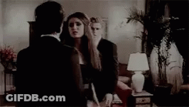 Group Standing Around Podium With Woman Screaming GIF