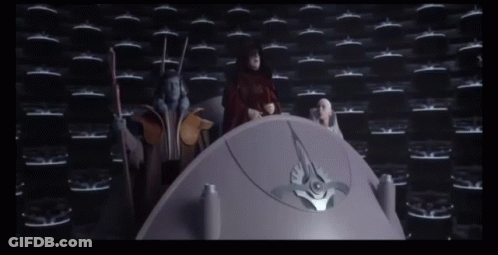 Group Standing Around Purple Object In Dark Room GIF