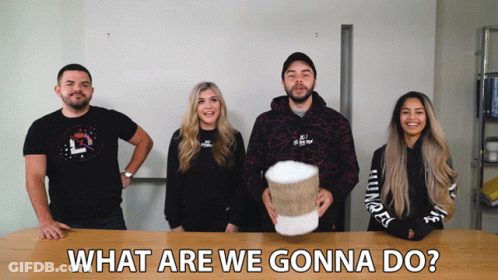 Group Standing Around Table What Are We Gonna Do GIF