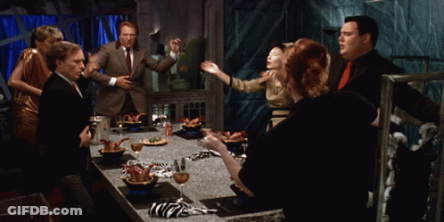 Group Standing Around Table With Food GIF