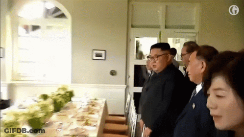 Group Standing Around Table With G GIF