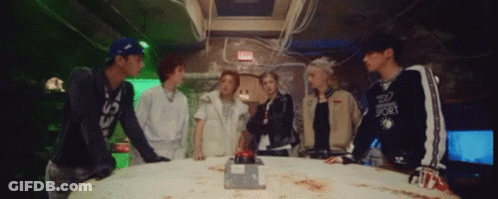 Group Standing Around Table With Red Exit Button GIF