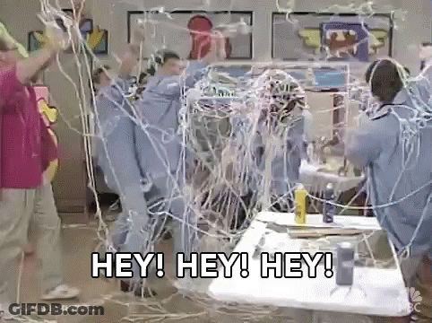 Group Standing Around Table With Wires GIF