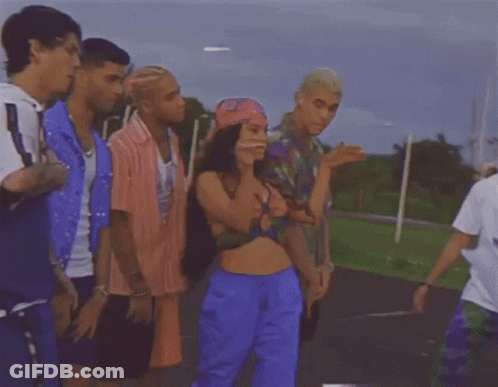 Group Standing Around Woman In Crop Top And Blue Shorts GIF