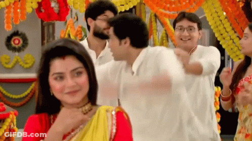 Group Standing Around Woman In Red And Yellow Sari GIF