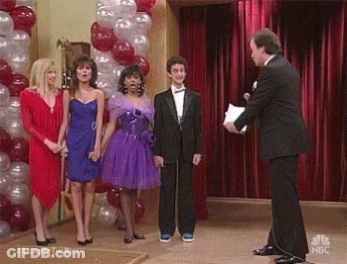 Group Standing Before Red Curtain With Balloons GIF