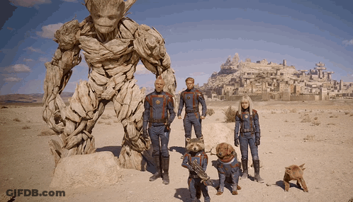 Group Standing Beside Statue GIF