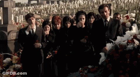 Group Standing In Circle Holding Roses In Front Of Tree GIF