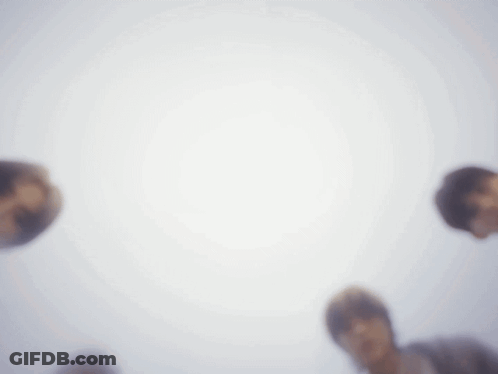 Group Standing In Circle Looking Up At Camera GIF