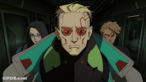 Group Standing In Dark Hallway With Red-Eyed Man GIF