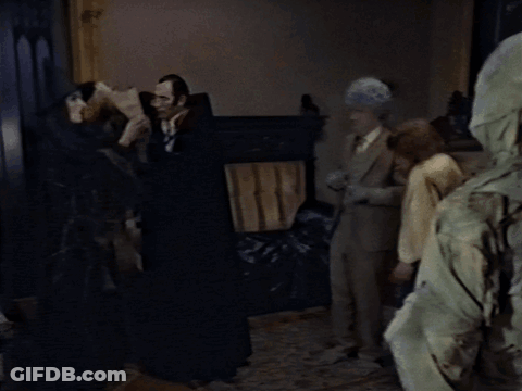 Group Standing In Dark Room One Wearing Hood GIF