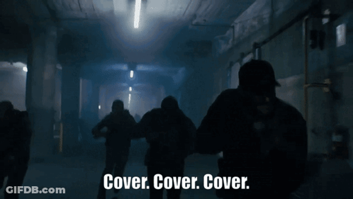 Group Standing In Dark Room Saying Cover Cover Cover GIF