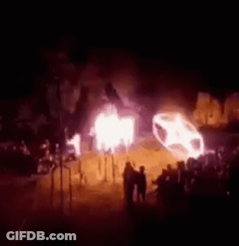 Group Standing In Front Of Burning Car GIF