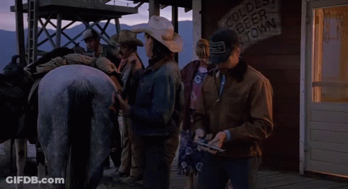 Group Standing In Front Of Cold Beer In Town Sign GIF