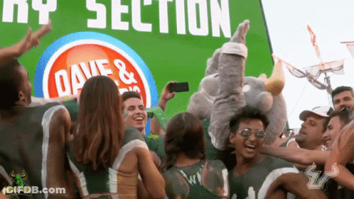 Group Standing In Front Of Dave's Sign GIF