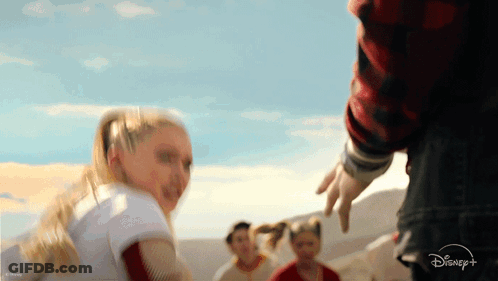 Group Standing In Front Of Disney Plus Logo GIF
