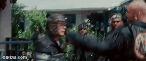 Group Standing In Front Of House With Man In Helmet GIF