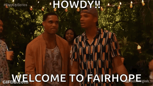 Group Standing In Front Of Howdy Sign GIF