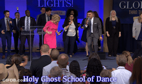 Group Standing In Front Of Lights And Holy Ghost School Of Dance Sign GIF