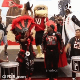 Group Standing In Front Of Mascot In Number 10 Jersey GIF