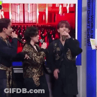 Group Standing In Front Of Pop Chart Show Sign GIF