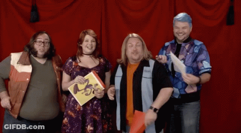 Group Standing In Front Of Red Curtain Holding ABC Book GIF