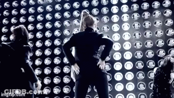 Group Standing In Front Of Wall Of Lights GIF