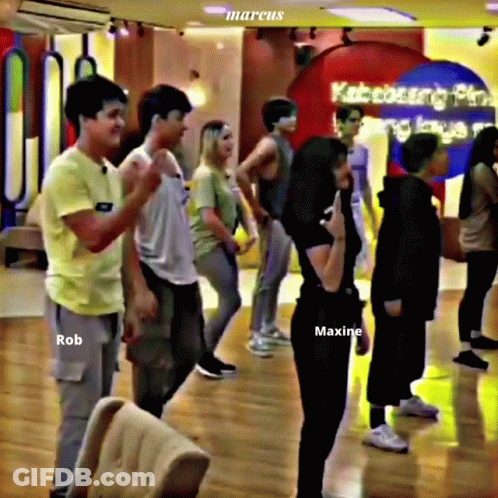 Group Standing In Room With Maxine Shirt GIF