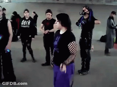Group Standing In Room With Shirt Saying Dark GIF