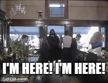 Group Standing In Room With Sign I'm Here GIF