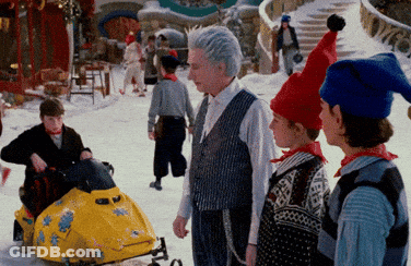 Group Standing In Snow With Snowmobile GIF