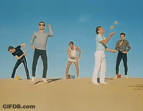 Group Standing On Sand Dune Arms Outstretched GIF