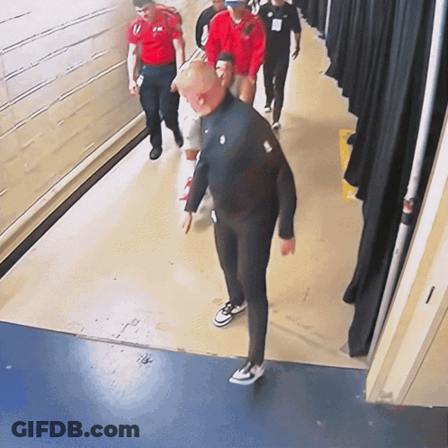 Group Walking Down Hallway With Nike Logo Jacket GIF