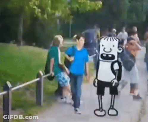Group Walking Down Path With Cartoon Character In Background GIF