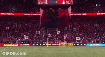 Group Walking Down Street With Ucgowell Sign GIF