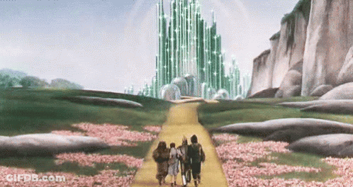 Group Walking Down Yellow Path To Green Building GIF