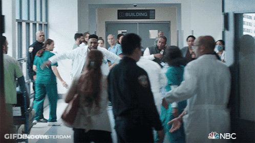 Group Walking In Hallway With Building Sign GIF