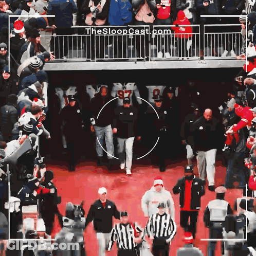 Group Walking On Red Carpet With Sloopcast.com On Fence GIF