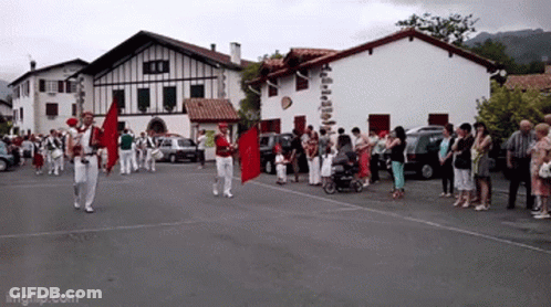 Group Walking With Red Flag In Front Of Building Saying Imgflip.com GIF
