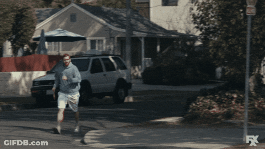 Guy Walking Fast On Roadside GIF