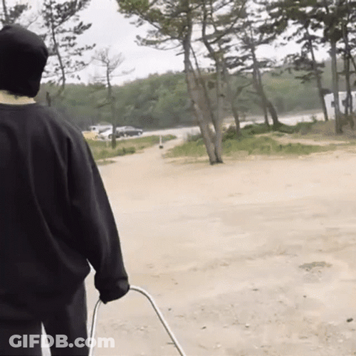Guy Walking While Dragging A Q Drum GIF