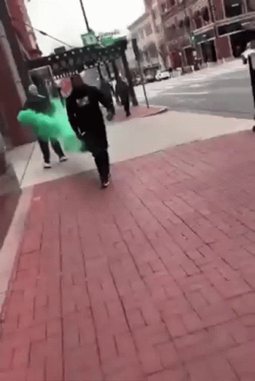 Guy Walking With Green Smoke Behind Him GIF