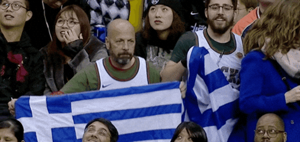 Guys Holding Flags Of Greece In The Audience GIF
