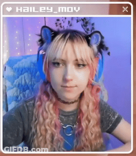 Hailey Moy Is Wearing A Cat Ear Headband And Headphones While Sitting In A Chair . GIF