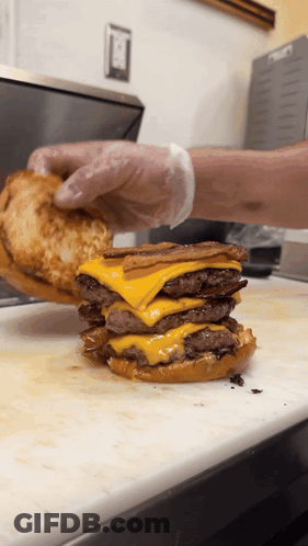 Hamburger Stacked On Another Hamburger On Cutting Board GIF