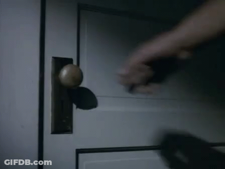 Hand Holding Door Handle In Dark Room GIF