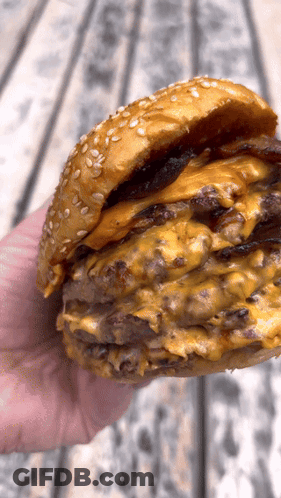 Hand Holding Hamburger With Cheese And Bacon GIF