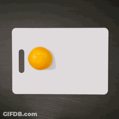 Hand Reaching For Orange On Cutting Board GIF