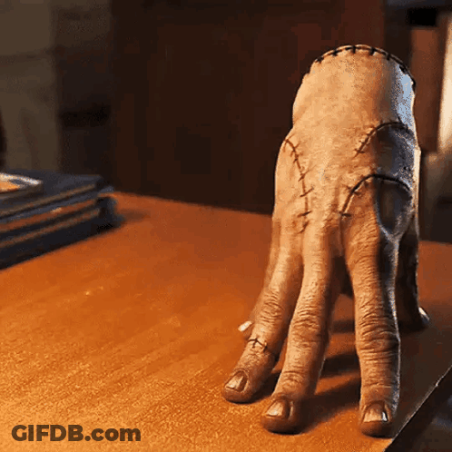 Hand With Stitches On Wooden Table GIF
